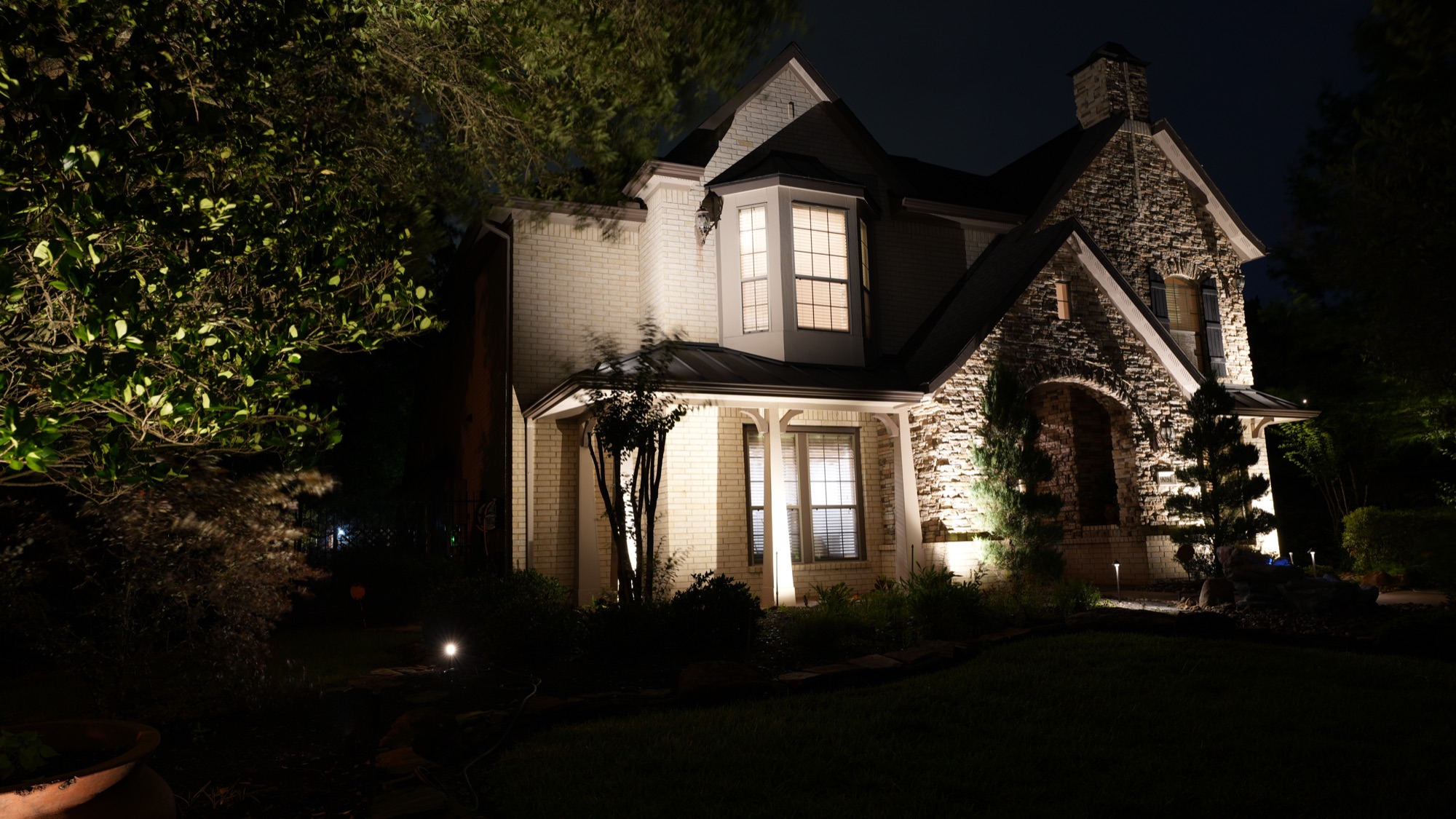Uplighting on stone arch entry and house facade, Williams residence Conroe TX